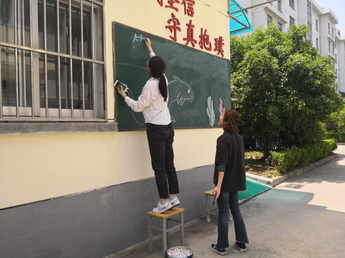 同学们正在画板报.jpg